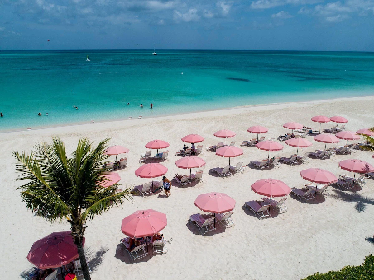 Aerial of Grace Bay with rows of pink umbrellas, Providenciales